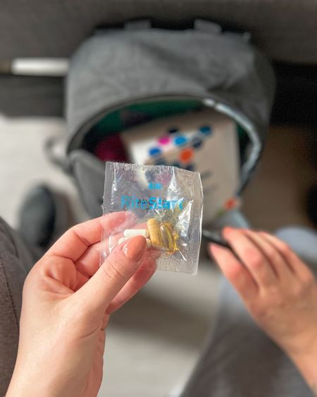 RiteStart™ Unisex Formula paketėlis laikomas rankose kasdienio naudojimo kontekste